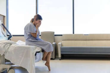 Young woman sitting alone, grieving after a miscarriage