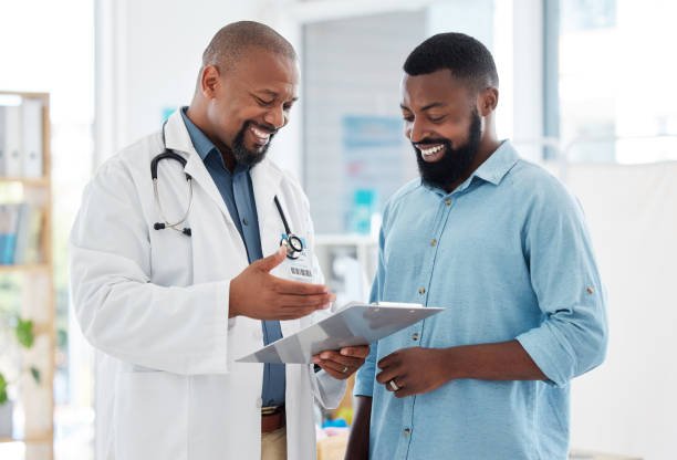 An African man sits calmly in a clinic, engaged in a relaxed consultation about vasectomy with a doctor