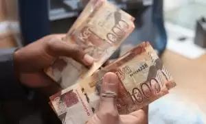 Two people exchanging cash during a meeting, illustrating financial fraud and money laundering risks in Kenya